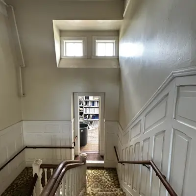 Staircase at east end of original 1889 building, looking down to the mid-floor landing storage room.