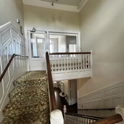 Staircase at east end of original 1889 building looking up at the 2nd floor landing.