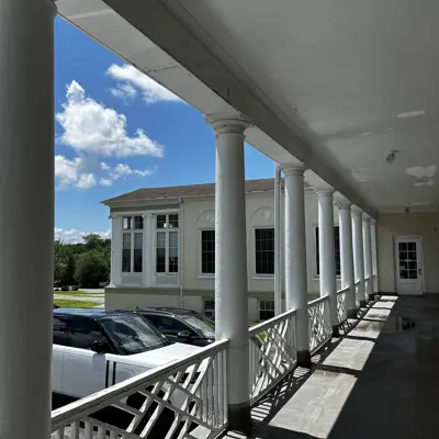 Porch on south side of 1889 building, looking west at the south wing of the 1924 addition.