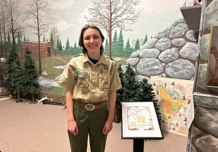 Kelly Griffiths at the Yorktown Museum with one of the QR code placards she created. Photo courtesy of the Town of Yorktown.