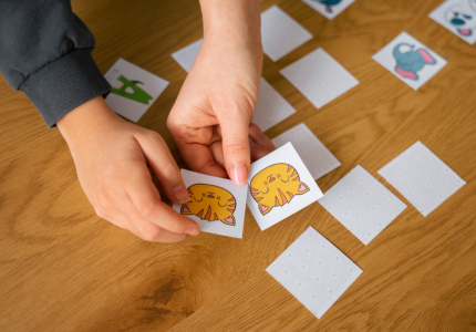 high angle kid playing memory game with parent. Image by FreePik.