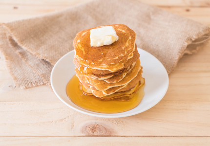 Image of pancakes with butter and syrup. Image by topntp26 on FreePik.