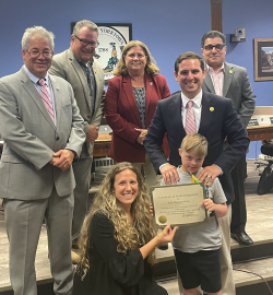 Members of the Town Board and the Town Clerk with Riley Manning-Burns on July 5, 2022, at Town Hall.