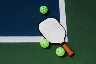 Image of pickleball racket and balls on a court